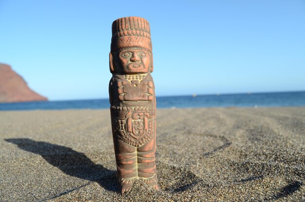 Oud Maya-beeld op het zandstrand