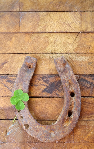 Oud paard shoewith klaverblad op houten achtergrond