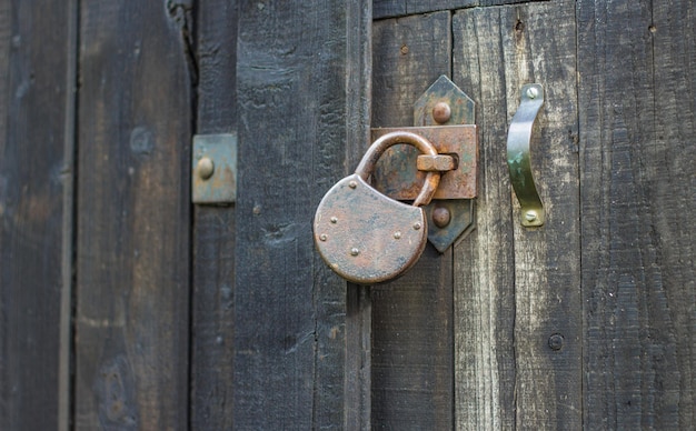 Oud roestig hangslot op houten poort