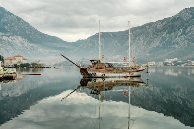 Foto oud schip in adriatische overzeese golf met bergen in montenegro kotor