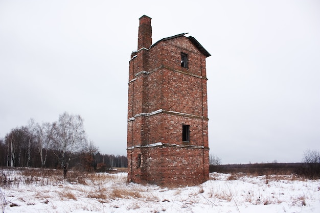 Oud verlaten bakstenen huis in een veld