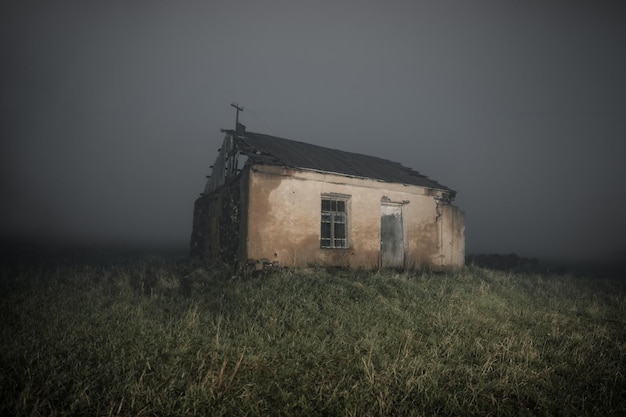 Oud verlaten huis in landschap