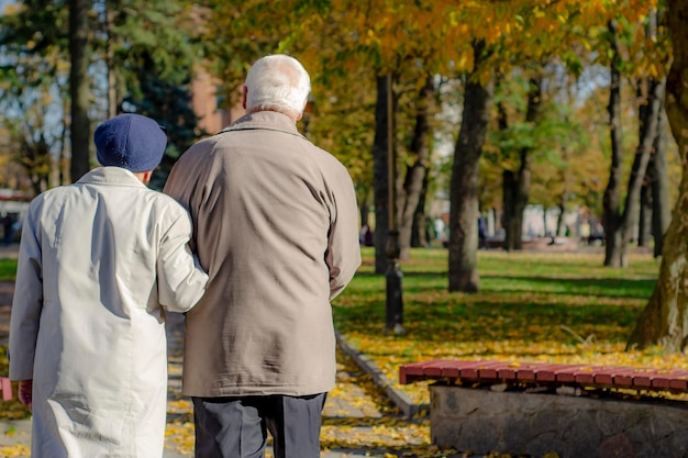 Oud volwassen stel achter je en kijk ergens Achteraanzicht van liefhebbend senior paar dat aan het wandelen is