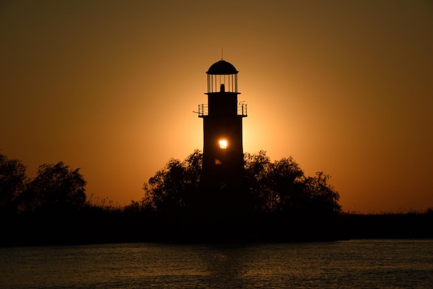 Oud vuurtorensilhouet bij zonsondergang in SulinaRoemenië