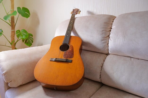 Oude akoestische gitaar op de bank in de woonkamer.