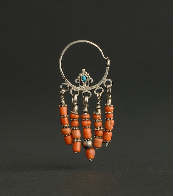Oude antieke oorbellen met stenen op zwarte achtergrond. Midden-Aziatische vintage sieraden