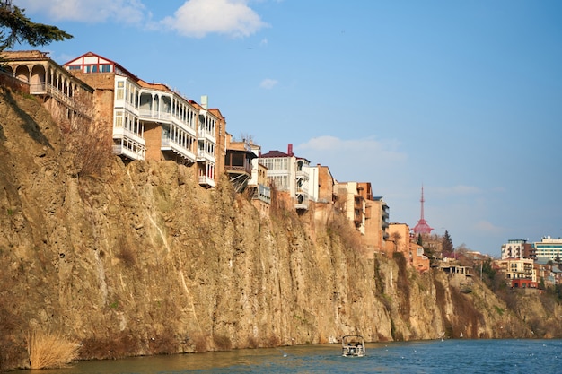 Oude architectuur van Tbilisi. Dichte ontwikkeling van een woongebouw op een klif aan de rivier.