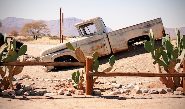 Oude auto in het zandlandschap