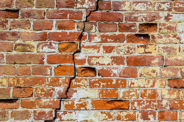 Oude bakstenen muur met grote barst