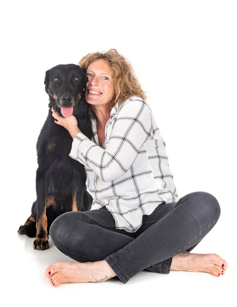 Oude beauceron en vrouw voor witte achtergrond