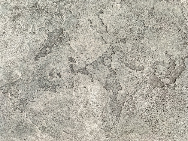 Oude beige muur bedekt met ongelijke gips. Textuur van de uitstekende sjofele oppervlakte van de zandsteen, close-up.