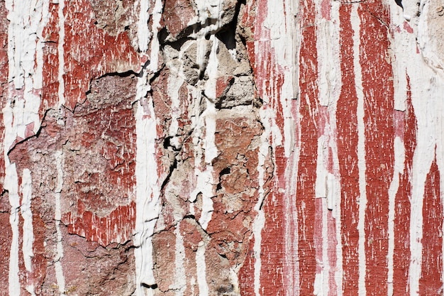 Oude beschadigde muur geschilderd met rood en wit