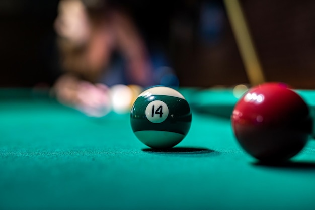 Oude biljartbal en stokkeu op een groene tafel Biljartballenconcept geïsoleerd op groene tafel