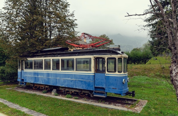 Oude blauwe elektrische tram staat op de rails