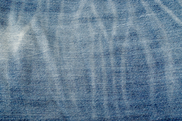 Oude blauwe jeans textuur achtergrond close-up. Denimstofpatroon, ruw katoenen doekbehang met exemplaarruimte