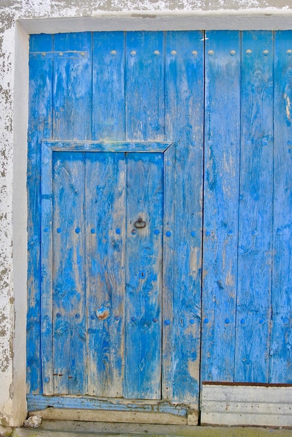 Oude blauwe schuurdeur op het platteland Gesloten armoedige vintage ingang naar het dorpsplein