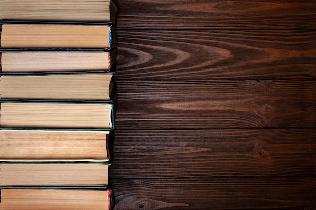 Oude boeken Een rij oude gebruikte stoffige gesloten hardcover boeken op een donkere houten achtergrond