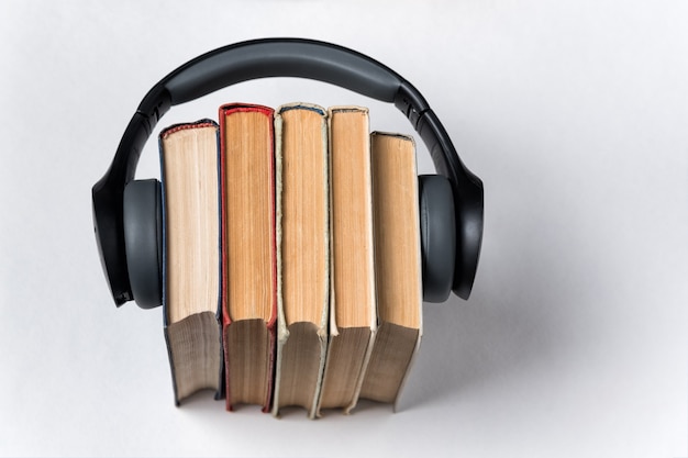 Oude boeken en koptelefoon op een wit. Audiobibliotheek concept.