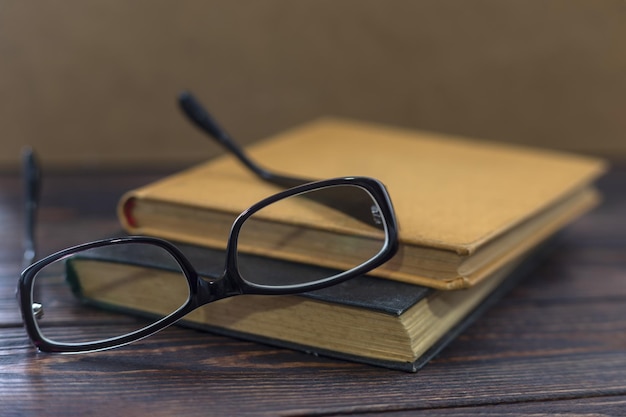 Oude boeken met vintage glazen op een houten tafel