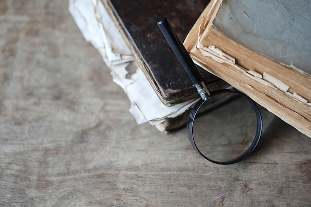 Oude boeken op een houten tafel en glazen vergrootglas