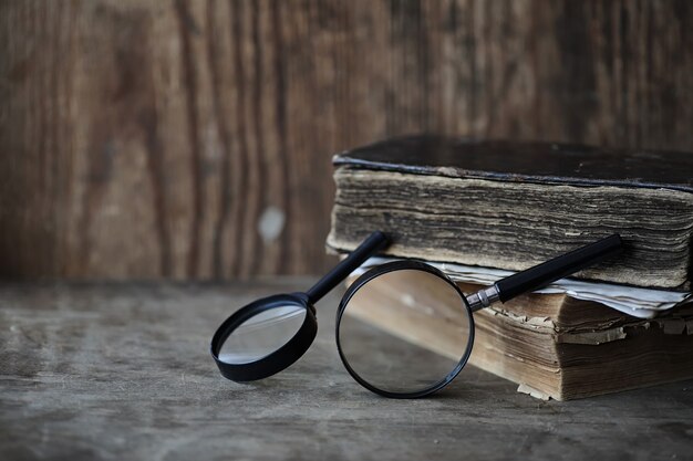 Oude boeken op een houten tafel en glazen vergrootglas