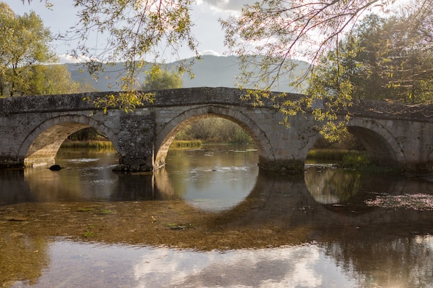 Oude brug op de rivier met oude boog