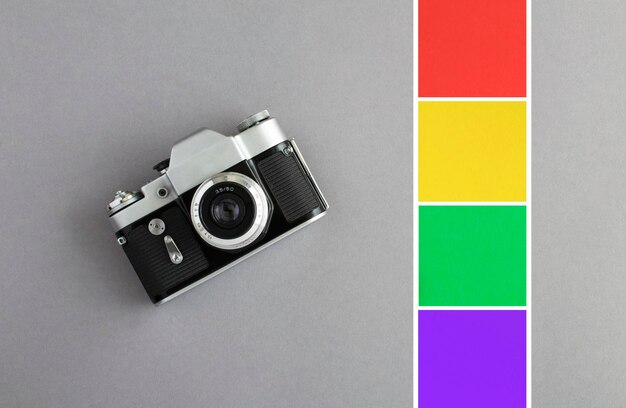 Oude camera en gekleurde vierkanten voor foto of tekst op de grijze achtergrond Bovenaanzicht Kopieer sace