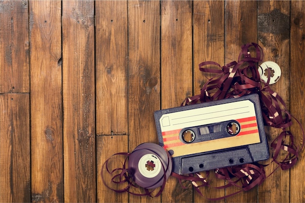 Oude cassette met verwarde band op houten ondergrond