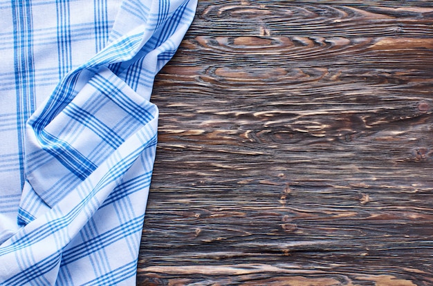 Oude donkere houten achtergrond. Houten tafel met blauwe keukendoeken