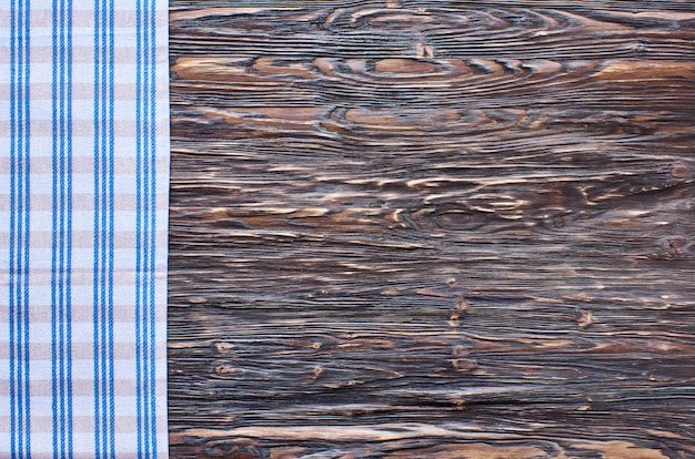 Oude donkere houten achtergrond. Houten tafel met blauwe keukendoeken