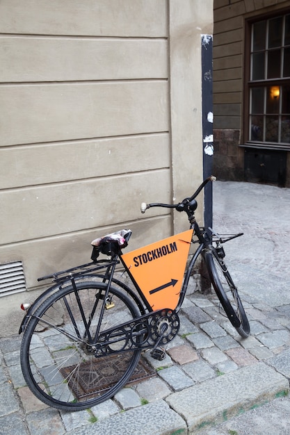 Oude fiets dichtbij muur in Stockholm, Sweden