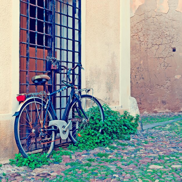 Oude fiets in de oude stad van Alghero in vintage toon