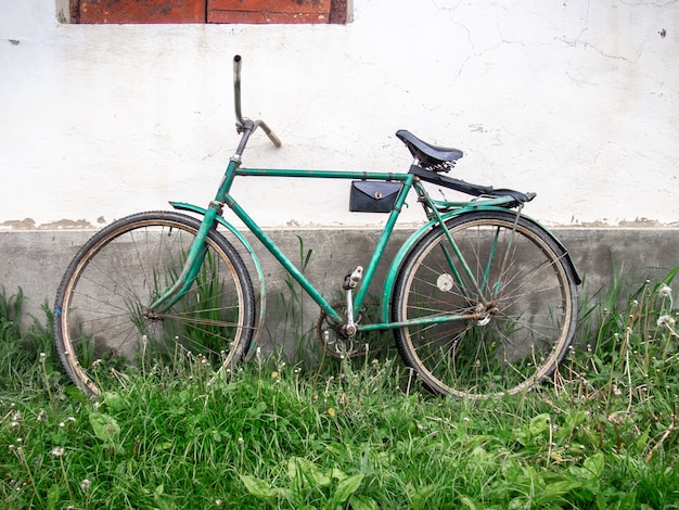 Oude fiets op de achtergrond van de muur.