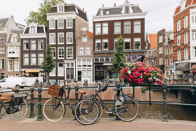 Oude fiets op de brug in Amsterdam Nederland tegen een gracht in de zomer Ansichtkaart iconisch uitzicht Toerisme concept