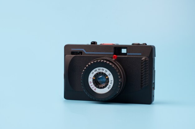 Oude filmcamera op een blauwe achtergrond. Creatief retro-ontwerp. Trendy vintage accessoires. Minimaal plat leggen.