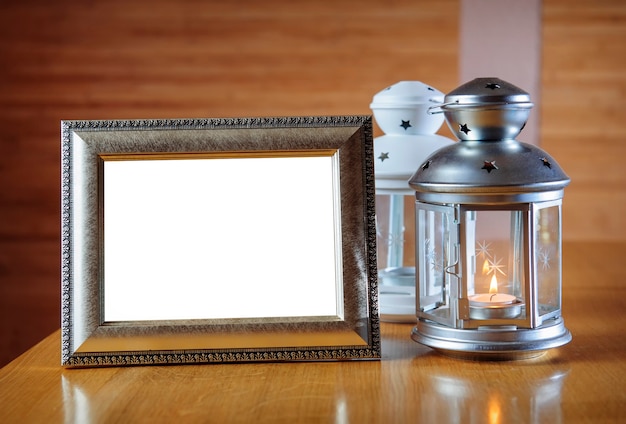 Oude fotolijst op de houten tafel en lantaarn met een kaars.