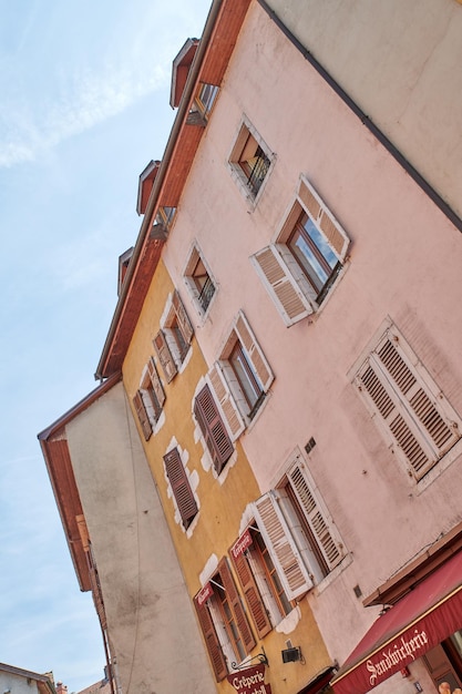 Oude gebouwen en middeleeuwse architectuur in een kleurrijke historische stad van onderen met een heldere blauwe lucht in Annecy Frankrijk Prachtig landschap van een kleine en lege stedelijke stad met huizen of huizen