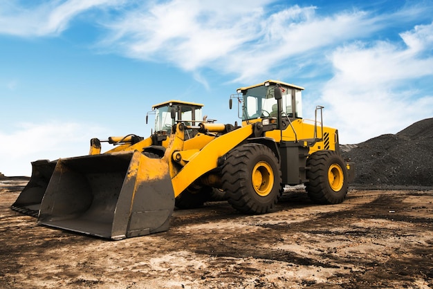 Foto oude gele bulldozer met rups bewegende grond met primeur. blauwe lucht en witte wolken op de achtergrond