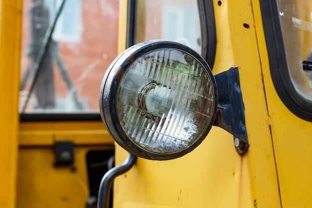 Oude gele vorkheftruck koplamp close-up