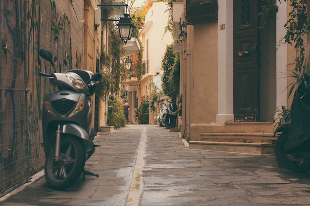 oude geparkeerde scooter en een vintage voordeur van het deel van de oude stad van stad Rethymnon.