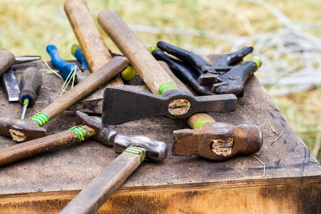 Oude gereedschappen hamers en tangen op een armoedige tafel.