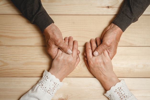 Oude handen van een bejaarde echtpaar samen, hand in hand