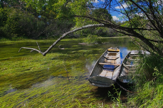 Oude houten boot aan de oever van een rivier