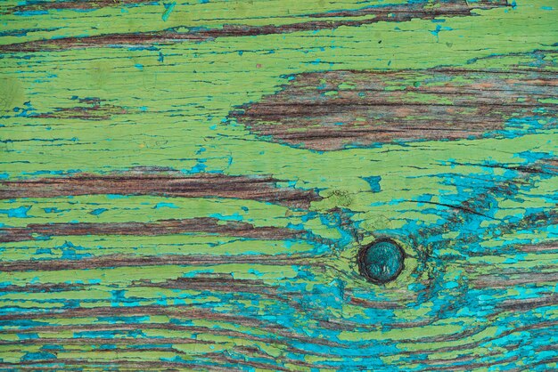 Oude houten geschilderde rustieke muur met blauwgroene schilferige kleurstof. vervaagd houten plankclose-up. verf aan boord schillen. gekraste ruwe houten textuur. onvolmaakt houtoppervlak. achtergrond met verweerde verf.