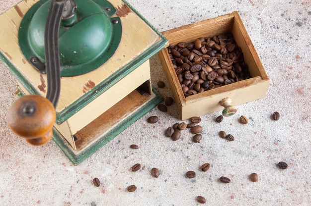 Foto oude houten koffiemolen op concrete achtergrond.