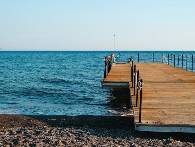 Oude houten pier en landschap van de blauwe zee