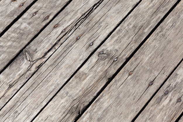 Oude houten planken met tekenen van beschadiging en vernieling, maken deel uit van de vloer van een huis of ander gebouw