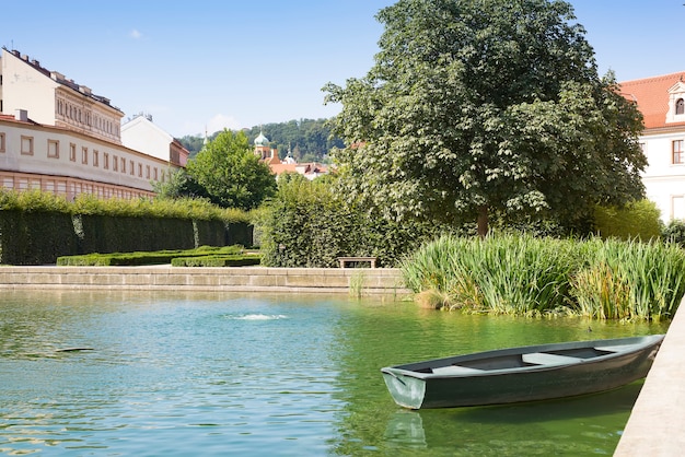 Oude houten roeiboot afgemeerd in tuin met zonstijging