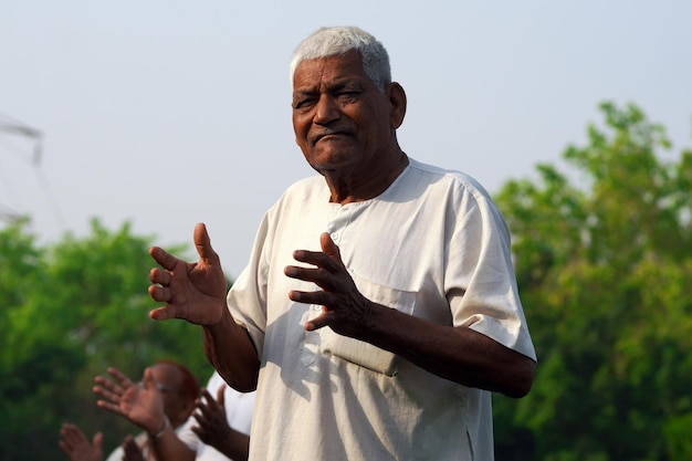 Oude Indiase man doet yoga buitenfotografie