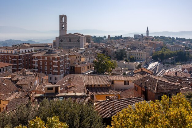 Oude Italiaanse stad op een heuvel met betegelde daken van gebouwen kerk en klokkentoren Perugia Italië